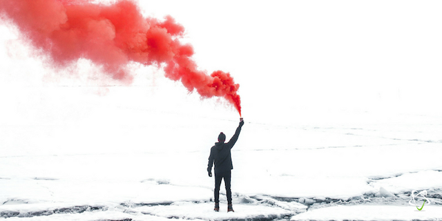 A man raising a red smoke bomb